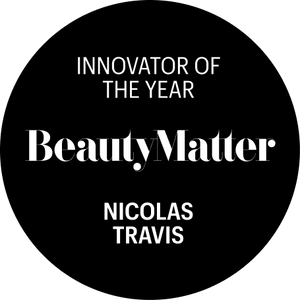 A black circular graphic with white text reading 'INNOVATOR OF THE YEAR BeautyMatter NICOLAS TRAVIS' on a white background.